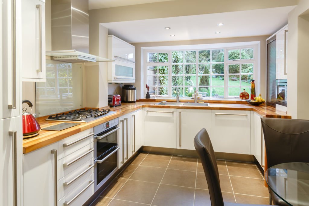 Modular modern kitchen interior with white units and contemporary dining area